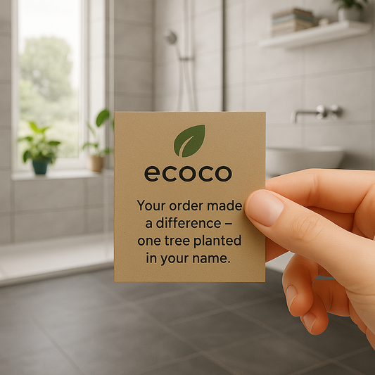 Hand holding a 'ecoco' card in a bathroom setting