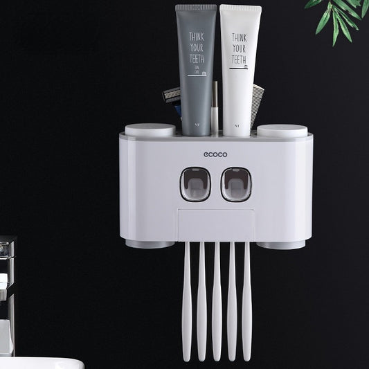 Pink-accented Ecoco automatic toothpaste dispenser with multiple slots for toothbrushes and storage compartments.
