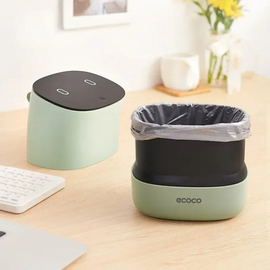 Sleek mini trash can with a soft-touch lid and built-in trash bag storage, perfect for home or office use.